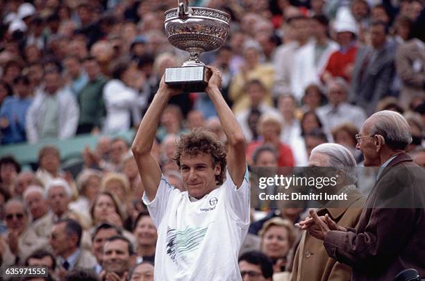 Mats Wilander lifts the winner's trophy for the crowd to see after winning the 1988 French Open.