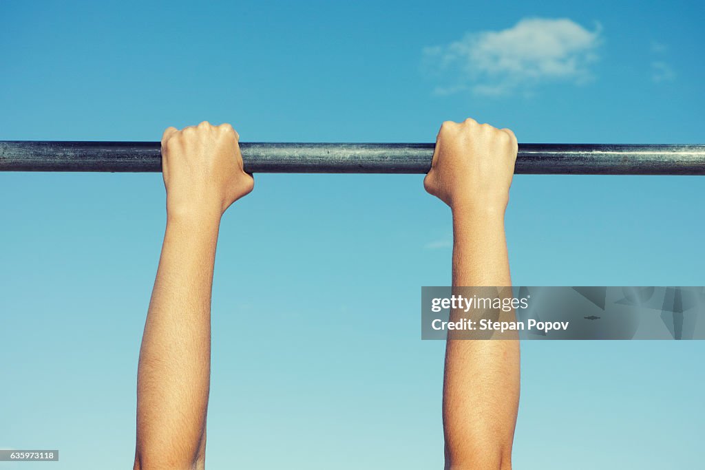 Person hanging on horizontal bar