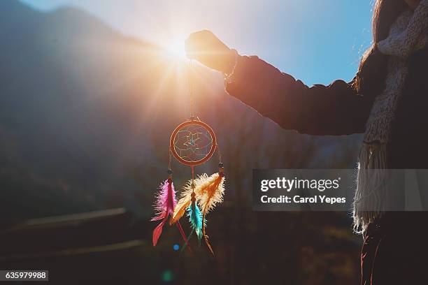 girl holding up a dream catcher on - dreamcatcher stock-fotos und bilder