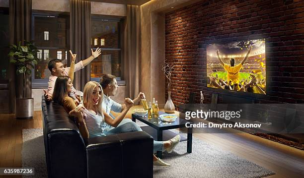 parejas aclamando y disfruta de los deportes en el televisor - dmytro aksonov fotografías e imágenes de stock