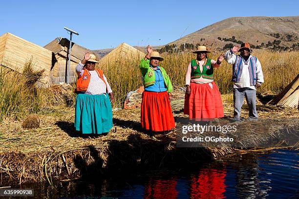 uros ureinwohner tragen traditionelle kleidung auf schwimmender insel - uros inseln stock-fotos und bilder