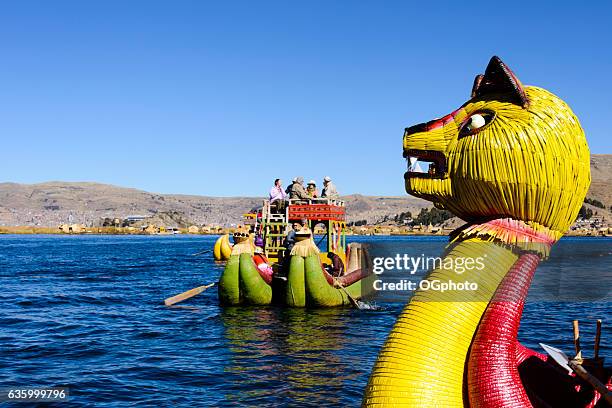 reed boat carrying tourists on lake titicaca, peru - uros stock pictures, royalty-free photos & images
