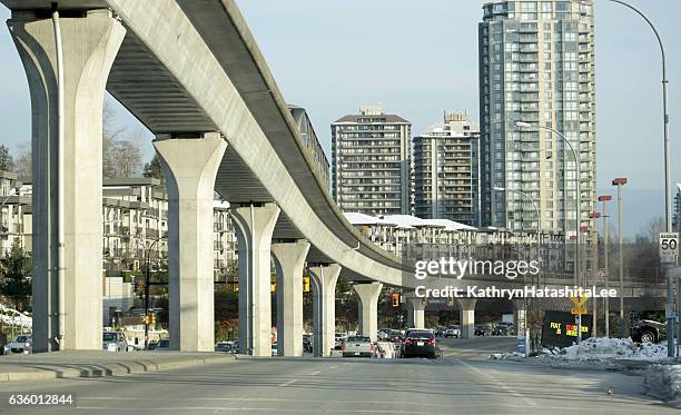 skytrain's millennium line above loughheed highway, burnaby, british columbia, canada - vancouver skytrain stock pictures, royalty-free photos & images