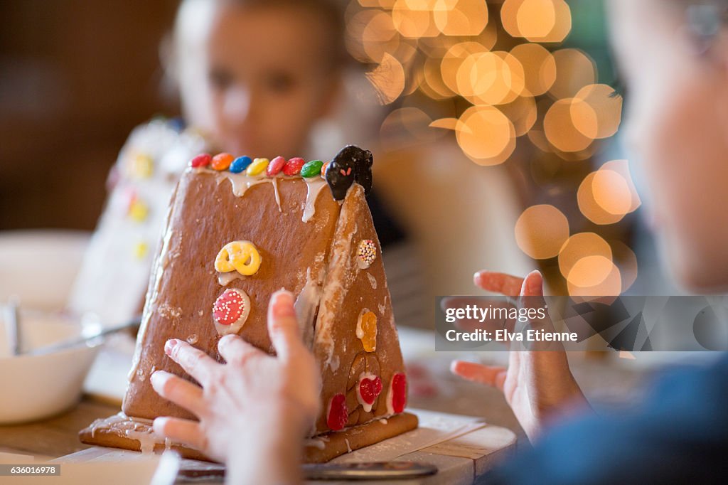 Children decorating gingerbread house