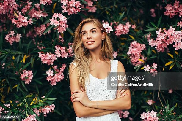 beautiful girl on the background of spring bush - curly blonde hair stock pictures, royalty-free photos & images