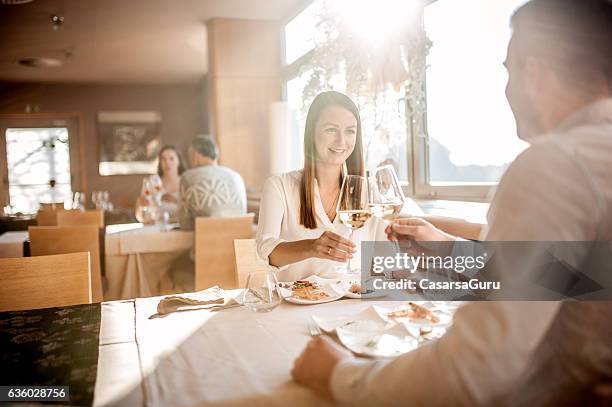 young couple on a romantic date in a restaurant - tafel voor twee stockfoto's en -beelden