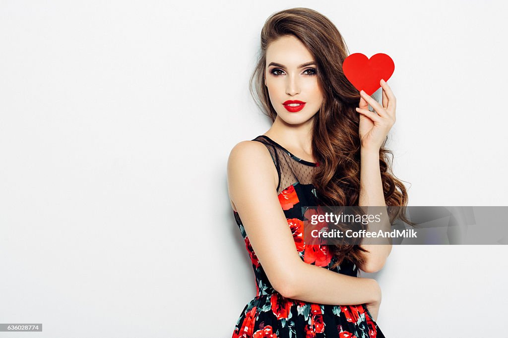 Beautiful woman holding artificial heart