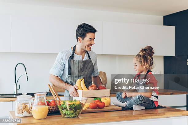 young man and a small girl in the kitchen - baby bag stock pictures, royalty-free photos & images