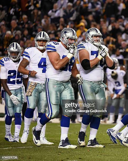 Offensive linemen Doug Free and Zack Martin, quarterback Dak Prescott and running back Lance Dunbar of the Dallas Cowboys walk to the line of...