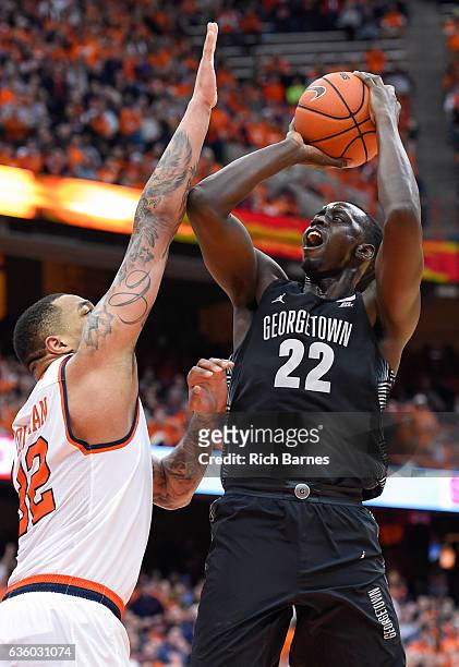 Akoy Agau of the Georgetown Hoyas shoots the ball as DaJuan Coleman of the Syracuse Orange defends during the first half at the Carrier Dome on...