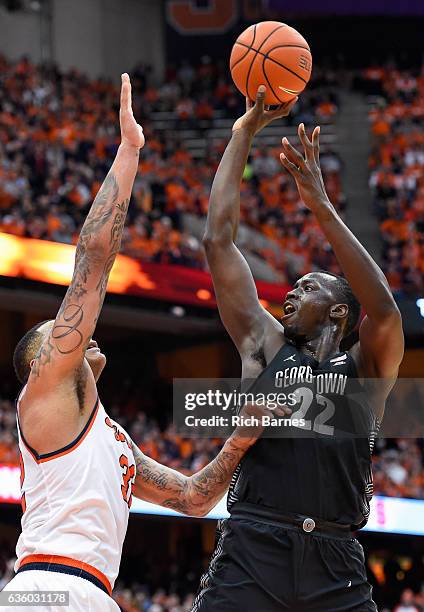 Akoy Agau of the Georgetown Hoyas shoots the ball as DaJuan Coleman of the Syracuse Orange defends during the first half at the Carrier Dome on...