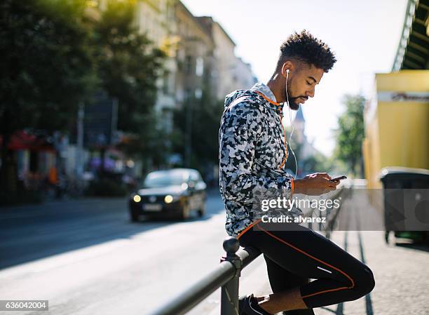 man taking a break after running session in city - man side way looking stock pictures, royalty-free photos & images