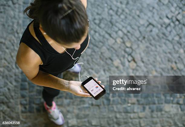 donna che monitora i suoi progressi di allenamento sull'app fitness - marcare sport foto e immagini stock