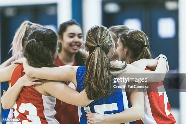 group of female high school basketball players encouraging one another - secondary school sport stock pictures, royalty-free photos & images