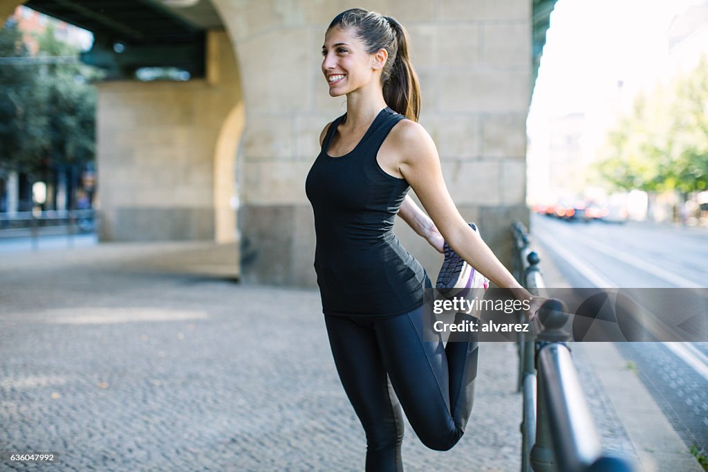Mujer joven de estiramiento las piernas después de correr