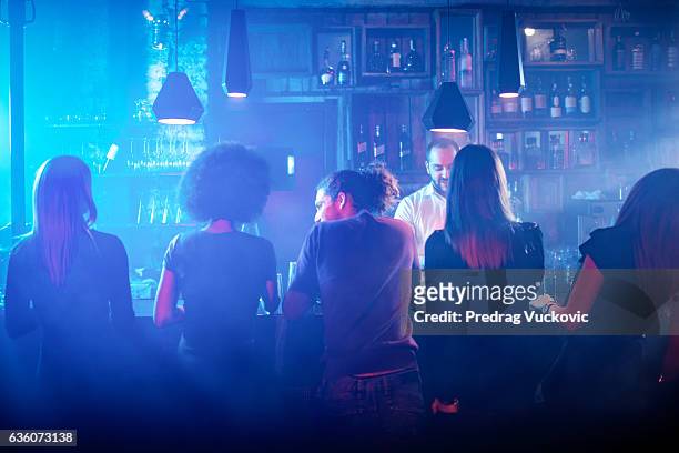 people sitting at the bar counter - horizontal bar stockfoto's en -beelden