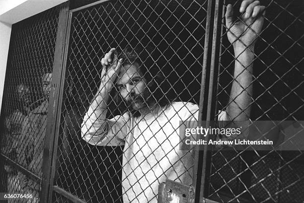 Suspected street dealers and their customers wait behind bars to be processed before being transferred to the city jail downtown, December 1, 1992....