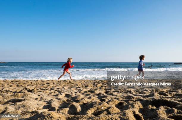 two kids running on beach, barcelona - barceloneta fotografías e imágenes de stock