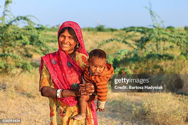 young indian woman holding her child - rajasthani dress stock pictures, royalty-free photos & images