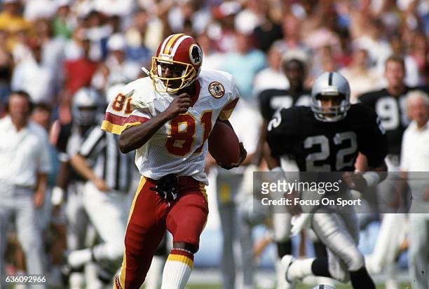 Wide Receiver Art Monk of the Washington Redskins runs with the ball after catching a pass against the Los Angeles Raiders during an NFL game circa...