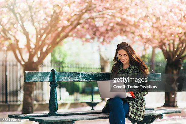 frau mit einem laptop im freien - arbeiten outdoor stadt laptop stock-fotos und bilder