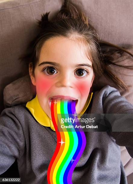 little girl using smartphone application changing her face. - child facebook stockfoto's en -beelden