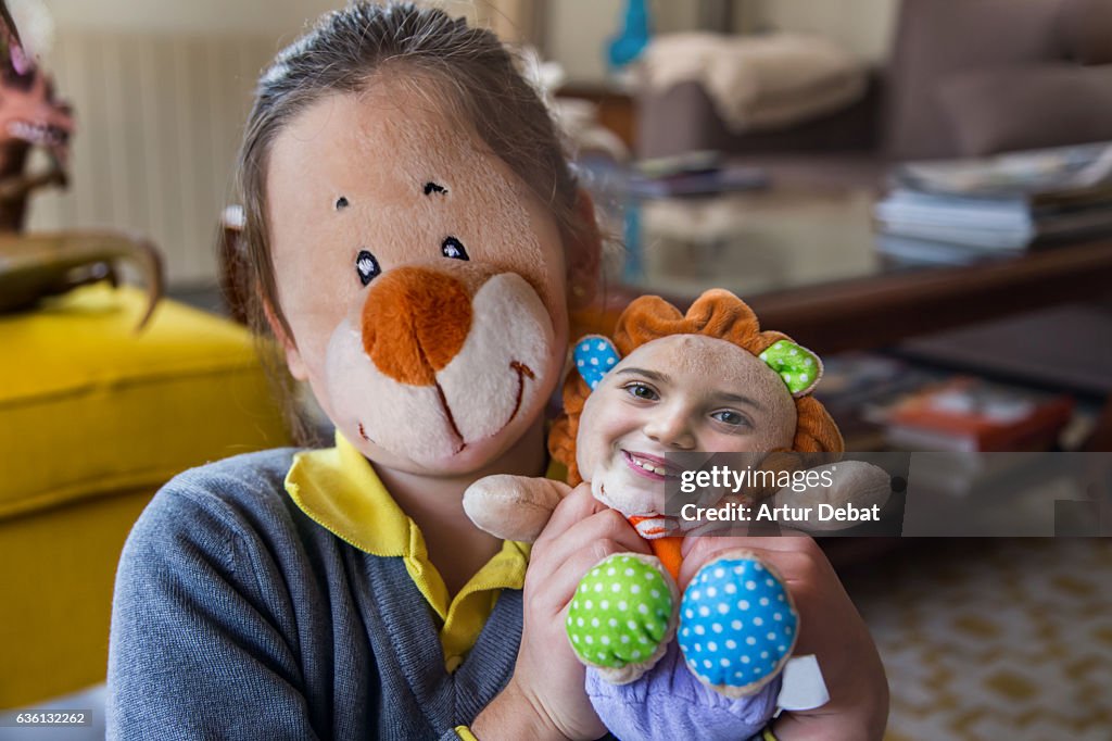 Funny picture swapping faces using smartphone application with little girl and her teddy toy.