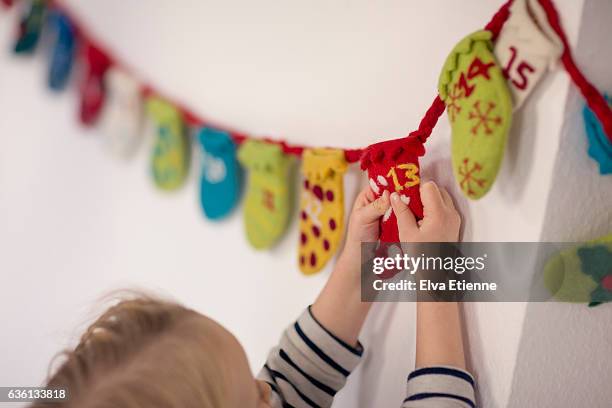 child opening advent calendar - kids advent stock pictures, royalty-free photos & images