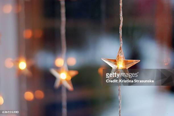 star shaped christmas lights in a window - winter decoration stock pictures, royalty-free photos & images