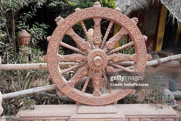 Stone carving of wheel.