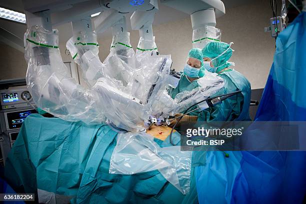 Reportage in an operating theatre during a hysterectomy using the da Vinci robot¬. A nurse and the surgeon position the robotÕs mechanical arm.
