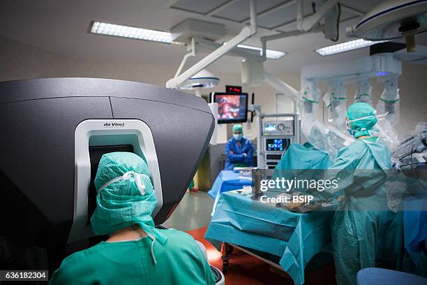 Reportage in an operating theatre during a hysterectomy using the da Vinci robot¬. The surgeon steers the robot from the console.