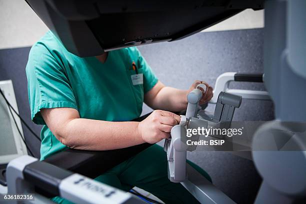 Reportage in an operating theatre during a hysterectomy using the da Vinci robot¬. The surgeon steers the robot from the console.