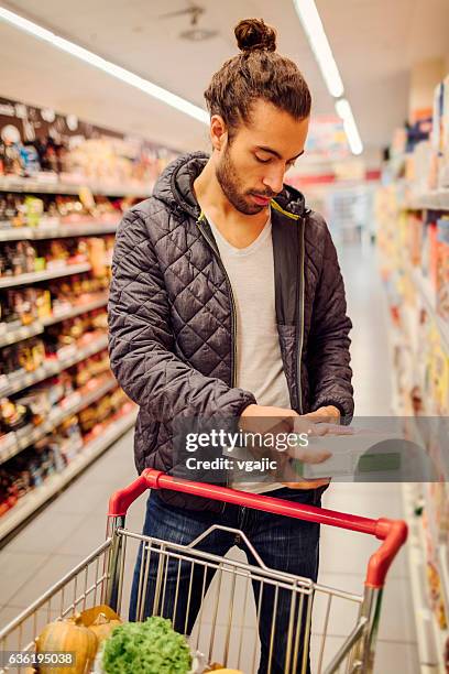 junge bärtige mann in einem supermarkt. - cereal box stock-fotos und bilder