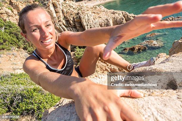 klettererin steigt steil über dem meer - freiklettern stock-fotos und bilder