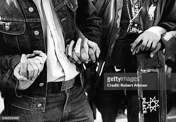 Couple hold hands and carry a guitar with Peace signs during "The March on Washington" on October 21, 1967 in Washington, D.C.