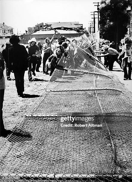 Protesters tear down the fence that was built by California Highway Patrol and Berkeley police officers when they destroyed trees, flowers and plants...