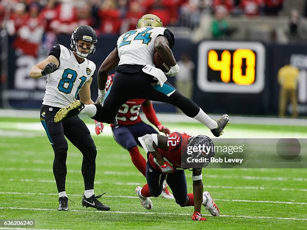 Weldon of the Jacksonville Jaguars hurdles Robert Nelson of the Houston Texans as Bryan Walters and Andre Hal look on at NRG Stadium on December 18,...