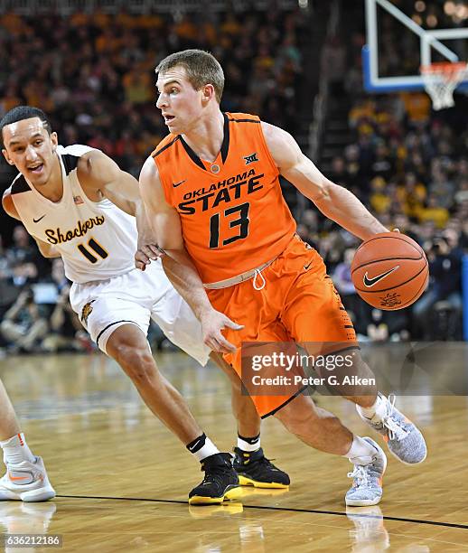 Guard Phil Forte III of the Oklahoma State Cowboys drives against guard Landry Shamet of the Wichita State Shockers during the first half on December...
