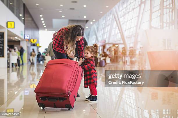 mutter und süße skleinkind mädchen ziehen zusammen einen koffer - toddler at airport stock-fotos und bilder