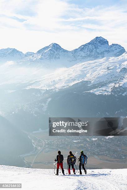 hikers walking on snow covered road in high mountain - st moritz stock pictures, royalty-free photos & images