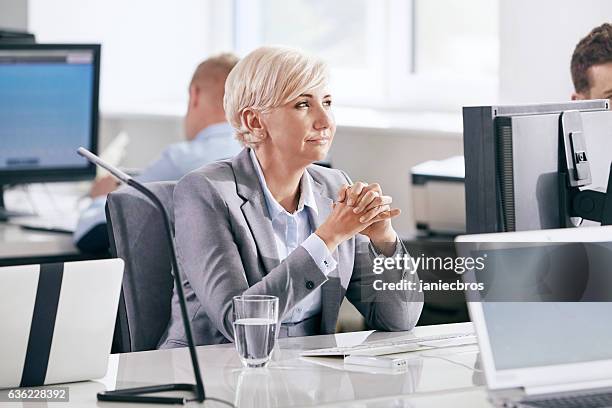 woman lost in thoughts at the office. planning and dreaming - smug stock pictures, royalty-free photos & images
