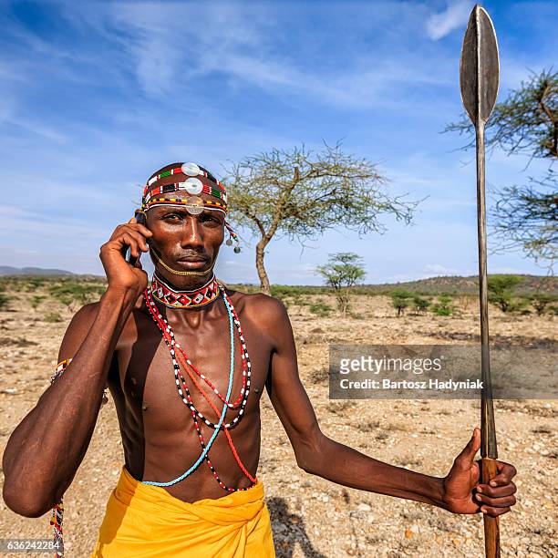 samburu tribe warrior using mobile phone, central kenya, east africa - speer stockfoto's en -beelden