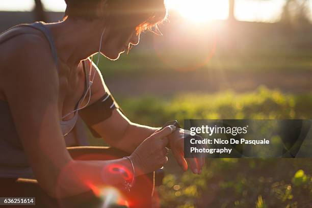 runner in the park using smart watch - best female performance stock pictures, royalty-free photos & images