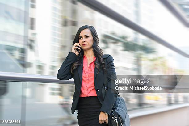 hispanic business women on phone walking in a rush - pencil skirt beautiful stock pictures, royalty-free photos & images