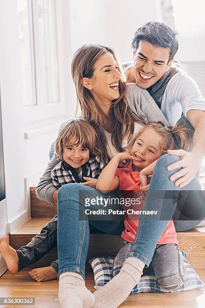 felice giovane famiglia con due bambini piccoli - vertical foto e immagini stock