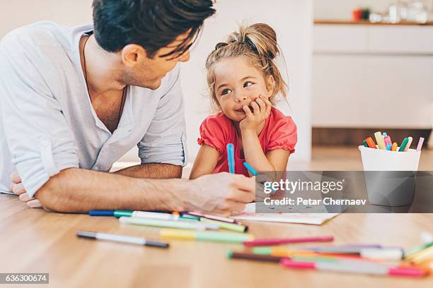padre e figlia che colorano sul pavimento - colorare foto e immagini stock