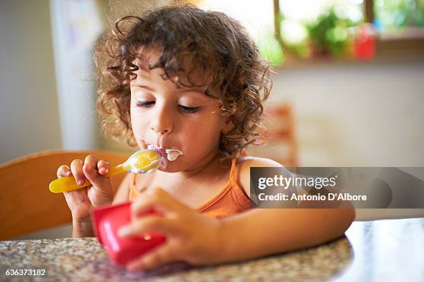 fille mangeant du yaourt - yaourt photos et images de collection