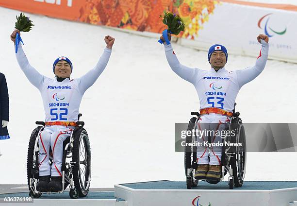 Russia - Japanese Alpine skiers Akira Kano and Taiki Morii celebrate on the podium at a medal ceremony for the sitting category of the men's super-G...