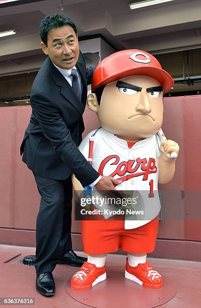 Japan - Former Hiroshima Carp outfielder Tomonori Maeda poses with a 130-centimeter-tall "Mae-tomo boya" mascot figure modeled after him at an...